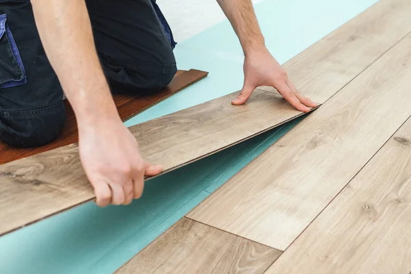 新しい薄板にされた木の床を取付ける労働者 フローリングの簡単かつ迅速なインストール ラミネートロックの接続 Diyフローティングフロア ラミネートフローリングを敷設する男性 男性の手でクローズアップ — ストック写真