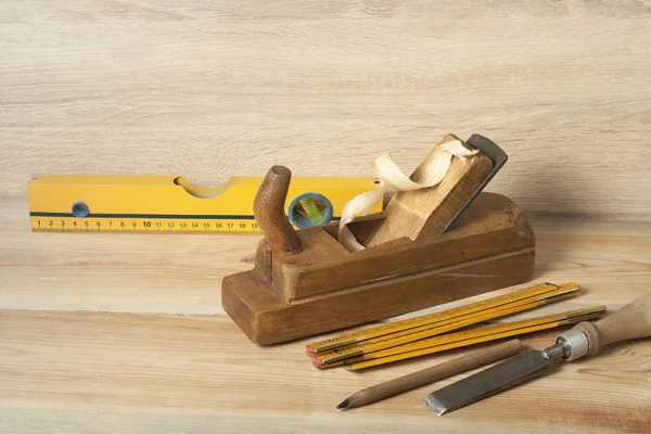 Carpentry concept.Joiner carpenter workplace. Old planer,level ,chisel and pencil on wooden table. Copy space for text. — Stock Photo, Image