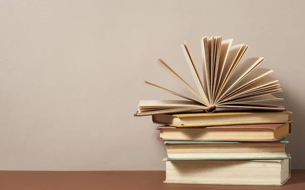 Offenes Buch und Bücherstapel auf Holztisch. Bildungshintergrund zurück zu Schul.Kopierplatz für Text. Stockfoto