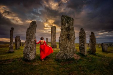 Woman in red dress at Callanish stones in sunset light, Lewis, Scotland clipart