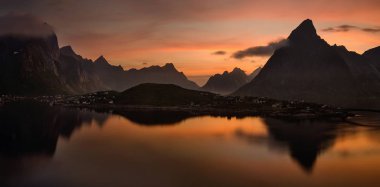 Arka planda, Lofoten karanlık Dağları ile Reine renkli gün batımı 