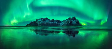 Stokksnes Aurora yansımaları merkezi, İzlanda Vestrahorn Dağları ile plaj siyah