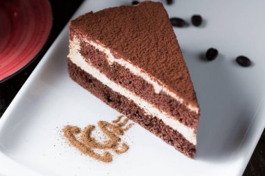 Beyaz porselen tabakta bir tiramisu pasta dilimi