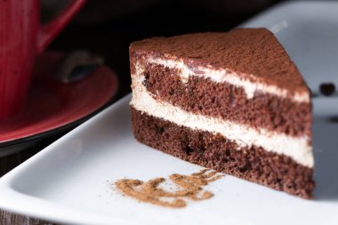 Bir tiramisu pasta beyaz plaka üzerinde çekim kapatın.