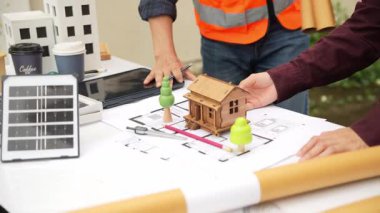 İnşaat mühendisi, müteahhit ve mimar inşaat alanında konuşuyor. Asyalı ustabaşı, inşaat sahasında planları tutuyor. Konut geliştirme projesi.