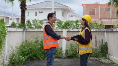 Asyalı bir kadın ustabaşı konut geliştirme projesinde kadın bir müteahhitle el sıkışıyor ve bir köy inşaatında müfettişle konuşuyor..