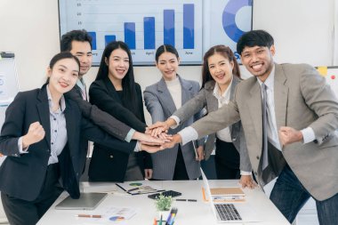 Bir grup Asyalı iş adamı şirket stratejisini planlamak için bir takım olarak çalışıyor. Başlangıç takım çalışması konsepti, el sıkışma konsepti ile günlük iş.