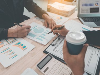 The meeting discussed charts and graphs showing the results of investments and business growth showing the results of investments, close-up.