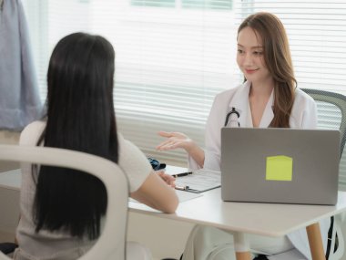 Asian doctor and patient discussing various topics while sitting at table. Concept of medicine and healthcare. Doctor and patient.