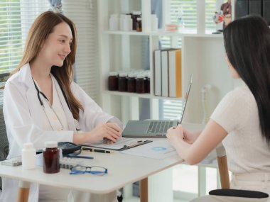 Asian doctor and patient discussing various topics while sitting at table. Concept of medicine and healthcare. Doctor and patient.