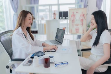 Asian doctor and patient discussing various topics while sitting at table. Concept of medicine and healthcare. Doctor and patient.