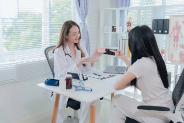 Female dentist talking to patient in dental clinic. Dentistry concept. Showing jaw model with braces to young female patient undergoing orthodontics.
