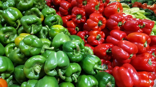 Meyve pazarında yığılmış taze ve doğal kırmızı ve yeşil biber