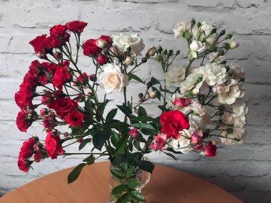 bir masada bir vazo beyaz ve kırmızı güller