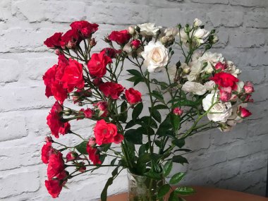 bir masada bir vazo beyaz ve kırmızı güller