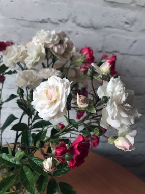 bir masada bir vazo beyaz ve kırmızı güller