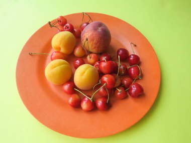 Şeftali, kayısı ve tatlı kiraz güzel bir plaka üzerinde yalan