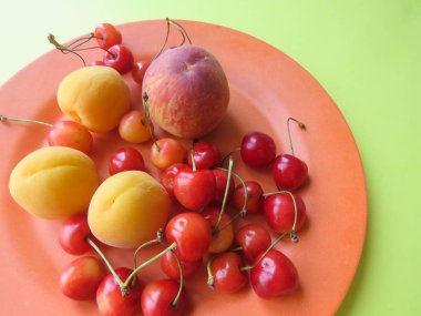 Şeftali, kayısı ve tatlı kiraz güzel bir plaka üzerinde yalan