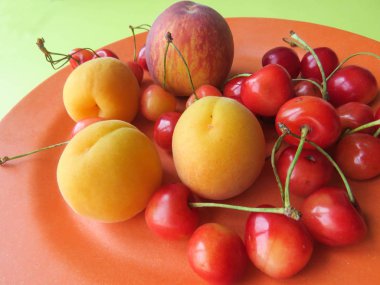 Şeftali, kayısı ve tatlı kiraz güzel bir plaka üzerinde yalan