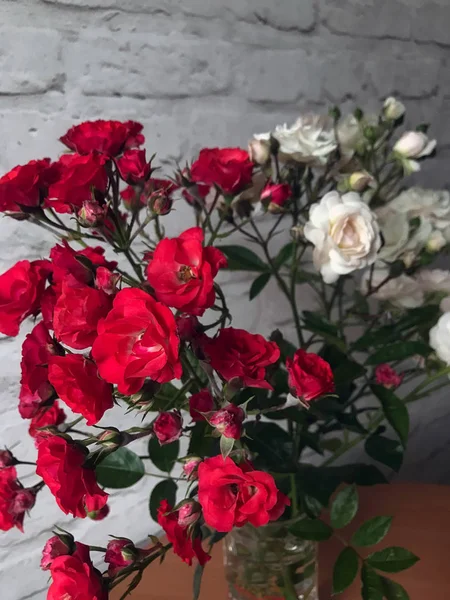 bir masada bir vazo beyaz ve kırmızı güller