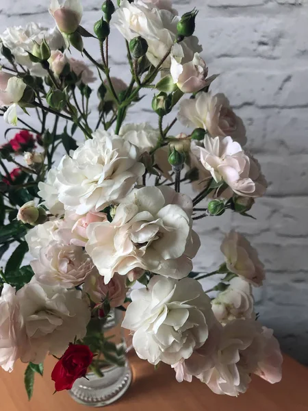 bir masada bir vazo beyaz ve kırmızı güller