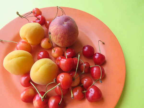 Şeftali, kayısı ve tatlı kiraz güzel bir plaka üzerinde yalan
