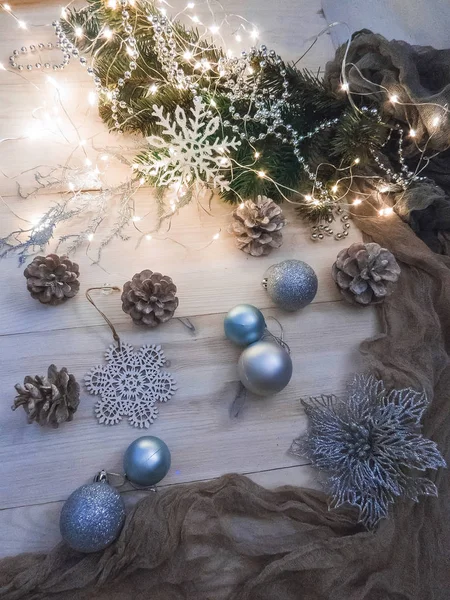 Nature morte hivernale avec guirlande, boules, pins et cônes sur un fond blanc en bois vue de dessus. noël — Photo