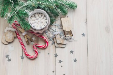 Beyaz fincan kakao bej örme giysiler için. Noel Baba kızağa, eldiven, şapka, kazak ve Noel ağacı ve metin için kırmızı karamelli şeker yer beyaz bir ahşap zemin üzerine çorap
