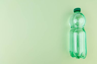 Yeşil elma ve su şişeleriyle yeşil arka planda sağIık ve denge