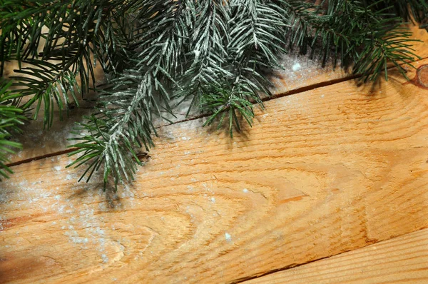 雪覆盖的圣诞树树枝与圣诞球在木头上 圣诞节背景 — 图库照片