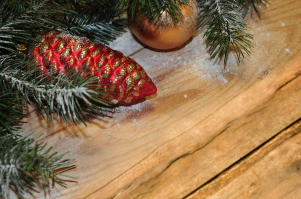 雪覆盖的圣诞树树枝与圣诞球在木头上 圣诞节背景 — 图库照片