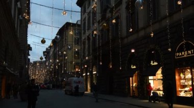 Floransa, Aralık 2018: Floransa 'nın merkezinde Noel ışıkları parlıyor. Turistler, Floransa 'nın merkezinin en ünlü caddelerinden biri olan Tornabuoni üzerinden alışverişe giderler. İtalya.