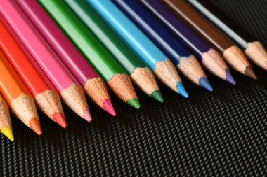 Siyah kauçuk arka planda renk kalemler. Close.