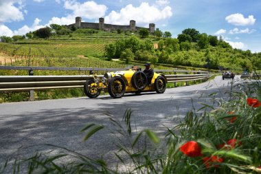 Toskana, İtalya - Mayıs 2019: Mille Miglia Tarihi Irkı ve Arka Planda Monteriggioni Kalesi tarihi geçit töreni kamu olay sırasında Bugatti Type 35 A 1925 üzerinde tanımlanamayan sürücüler.