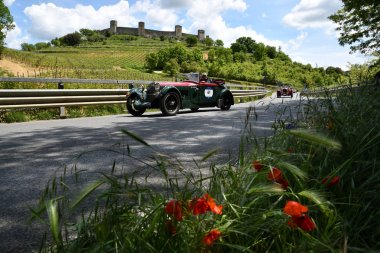 Toskana, İtalya - Mayıs 2019: Alfa Romeo 6c 1750 Ss Young 1929 üzerinde mille Miglia tarihi geçit töreni ve arka planda Monteriggioni Kalesi kamu olay sırasında tanımlanamayan sürücüler. İtalya.