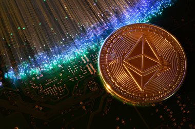 Renkli fiber optikile aydınlatılmış basılı elektronik devre kartıüzerinde kripto para birimlerini temsil eden Ethereum Eth.