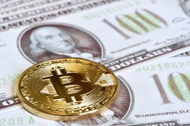 Altın Bitcoin yüz dolar faturaları üzerinde. Yakın çekim, makro çekim.