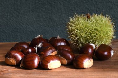 Kestanelere yakın çekim ve tahta arka planda kıvırcık. Noel için çiğ kestane.
