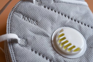 KN95 ya da N95 maskesinin detayı. 2.5 numaralı vana ve siyah arka planda Corona virüsü korunması için. Virüsün yayılmasını önlemek ve salgın COVID-19.