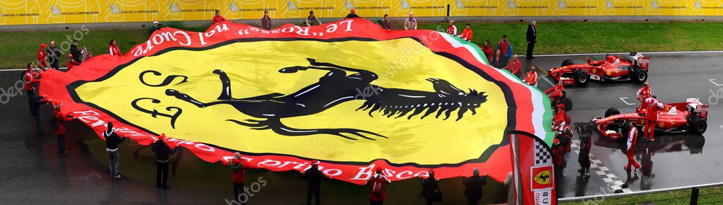 MUGELLO, IT, November 2013: fans with a giant banner of the Ferrari Logo on the finish line of the Mugello Circuit in Italy during the 2013 Ferrari World Finals. Italy.