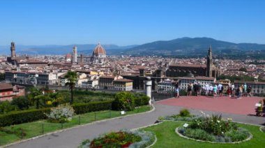 Floransa, Haziran 2019: Piazzale Michelangelo 'dan Floransa' da solda Santa Maria del Fiore 'nin ünlü katedrali ve sağda Kutsal Haç Bazilikası ile kentin ufuk çizgisine hayran turistler görülüyor. Toskana, İtalya.