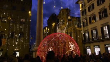 Floransa, Aralık 2019: Noel zamanı Floransa 'nın merkezi. Santa Trinita Meydanı 'nda turistlerle Noel ışıkları süslemeleri. 4K UHD Video