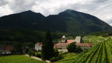 Güney Tyrol 'daki yeşil şarap bağlarıyla çevrili Novacella Manastırı' nın muhteşem manzarası. Bressanone, İtalya. Zaman ayarlı. eğik kamera hareketi.