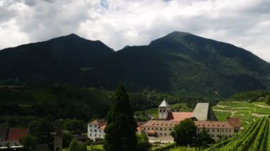 Güney Tyrol 'daki yeşil şarap bağlarıyla çevrili Novacella Manastırı' nın muhteşem manzarası. Bressanone, İtalya. Zaman ayarlı. pan kamera hareketi.