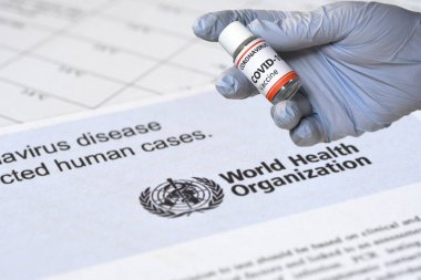 Floransa, Eylül 2020: Coronavirus Aşı Konsepti. Mavi eldivenli bir doktorun elinde Birleşmiş Milletler Dünya Sağlık logosu üzerinde Covid-19 'a karşı bir aşı kavanozu var..