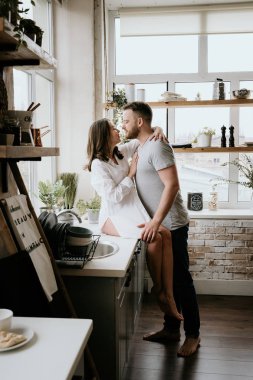 Romantik genç çift mutfakta birlikte yemek pişiriyor, birlikte harika vakit geçiriyorlar..