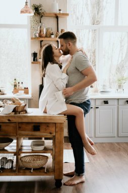 Romantik genç çift mutfakta birlikte yemek pişiriyor, birlikte harika vakit geçiriyorlar..
