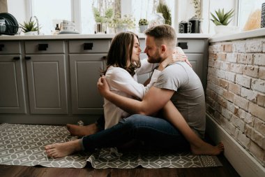 Romantik genç çift mutfakta birlikte yemek yapıyor. Beyaz gömlekli kız. Birlikte kahvaltı.