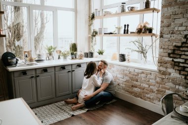 Romantik genç çift mutfakta birlikte yemek yapıyor. Beyaz gömlekli kız. Birlikte kahvaltı.