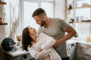 Romantik genç çift mutfakta birlikte yemek yapıyor. Beyaz gömlekli kız. Birlikte kahvaltı.